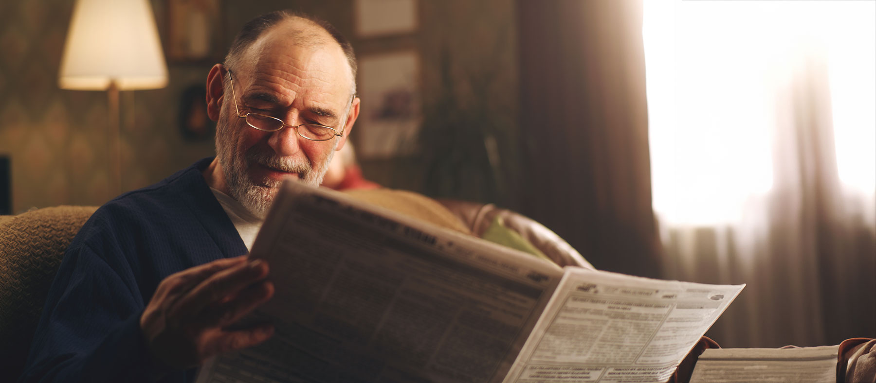 ጋዜጣውን እያነበበ ያለ ሰው